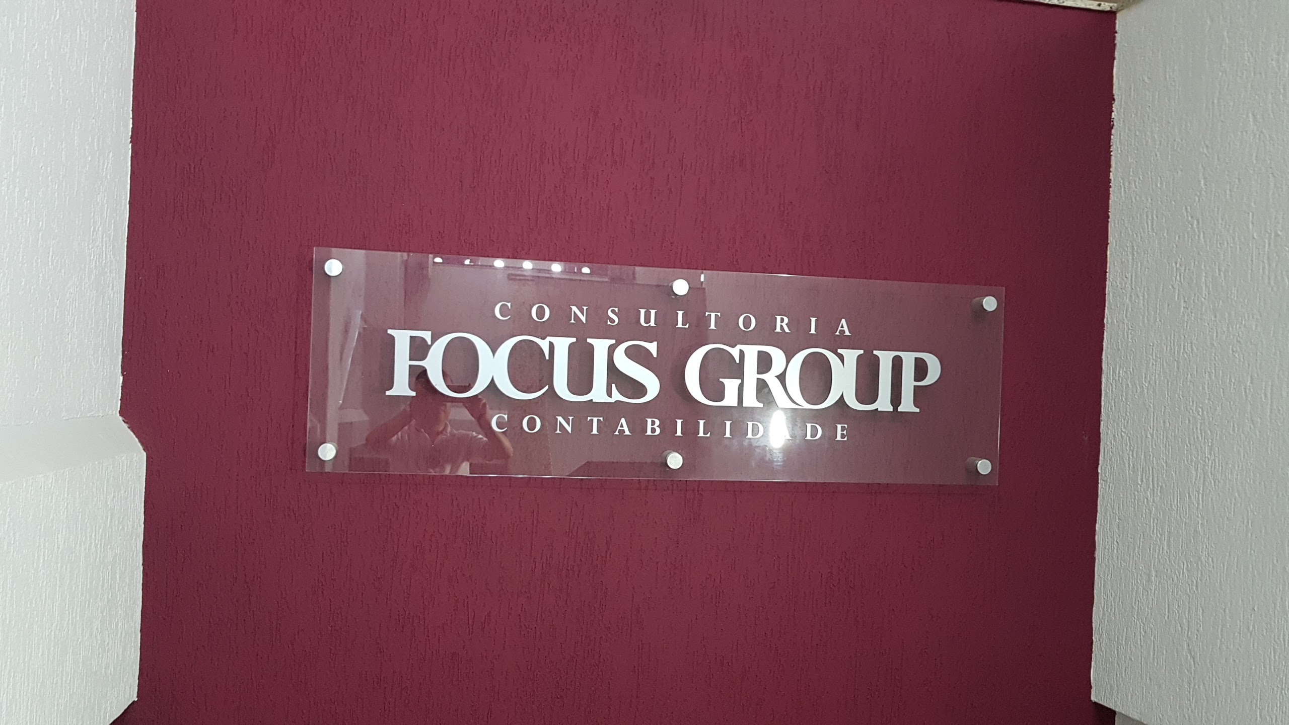 Logo da Focus Group na parede vinho do escritório